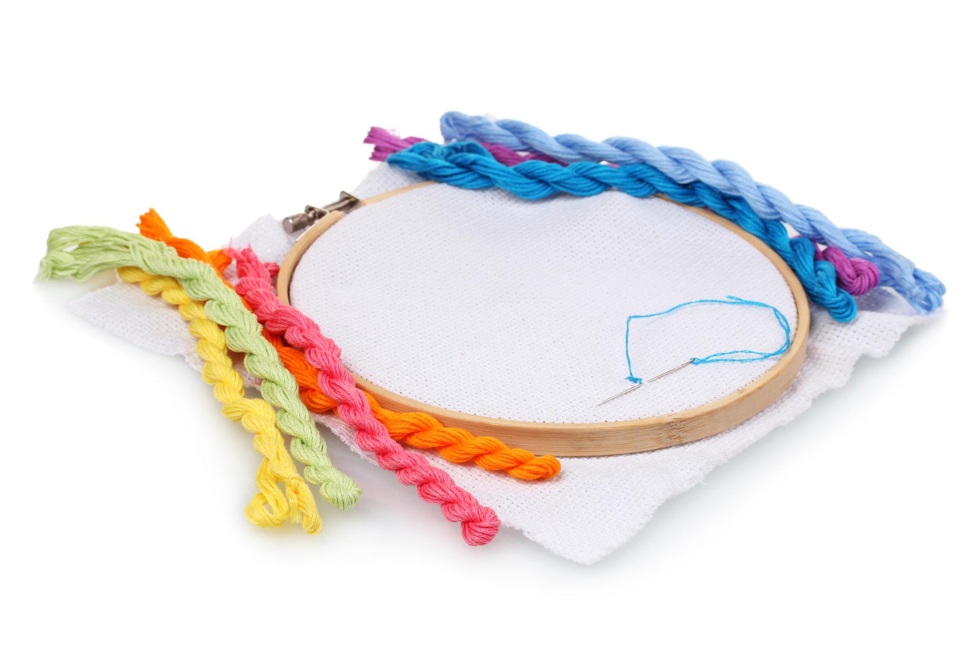 close-up of hand-guided embroidery hoop with colorful thread